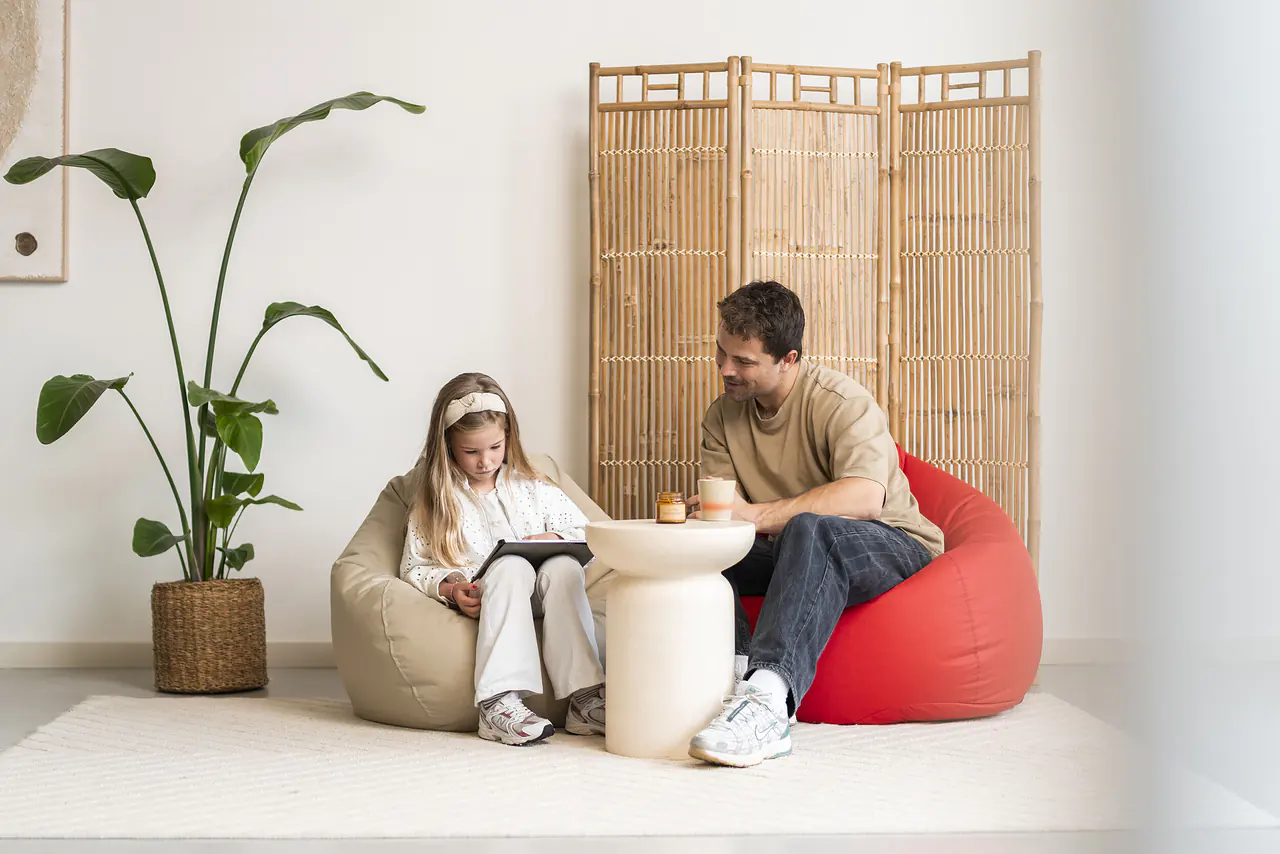 Vader en dochter spelen samen op Pear zitzakken met een rode zitzak
